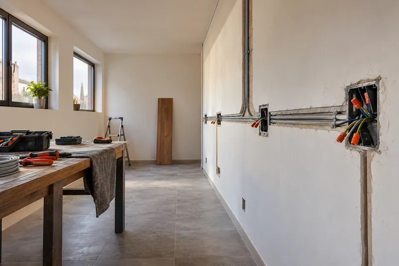 Visualización conceptual IA: Canalizaciones y cajas eléctricas durante la preparación de una cocina.